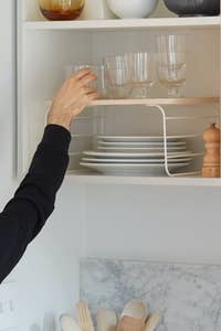 A hand reaching for a glass on top of the riser