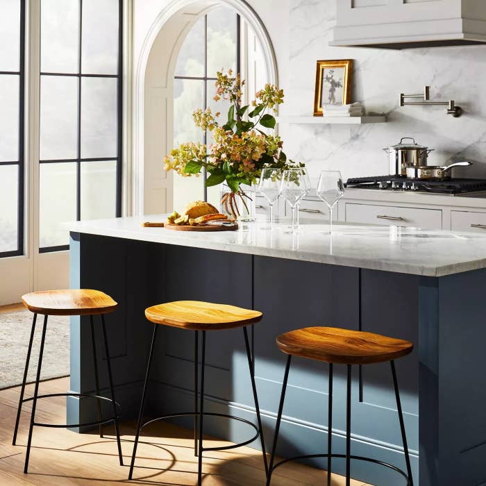 Three of the metal and wooden stools in front of a kitchen island