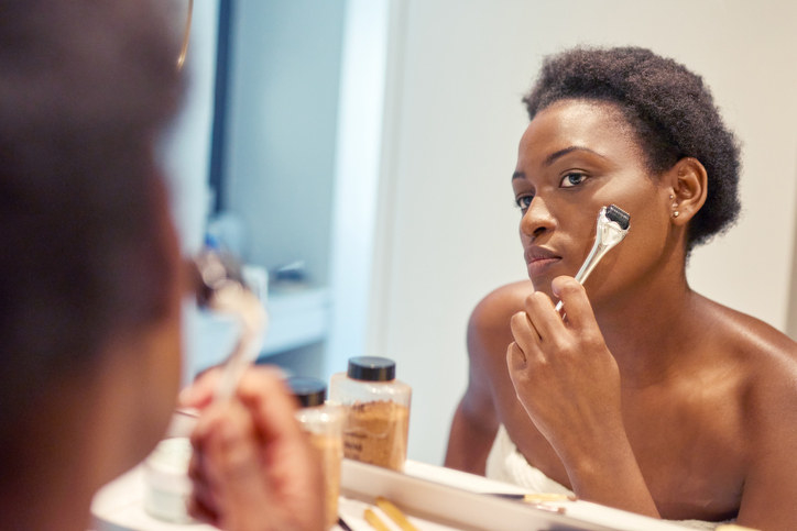 A woman rolling something over her cheek