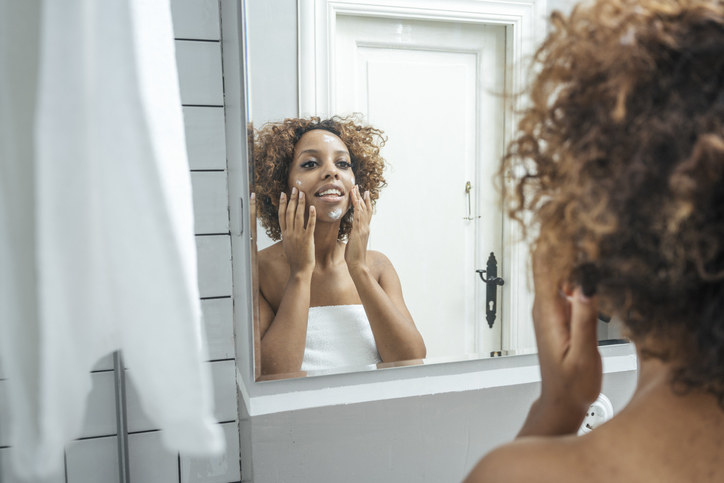 a woman rubbing moisturizer on her face