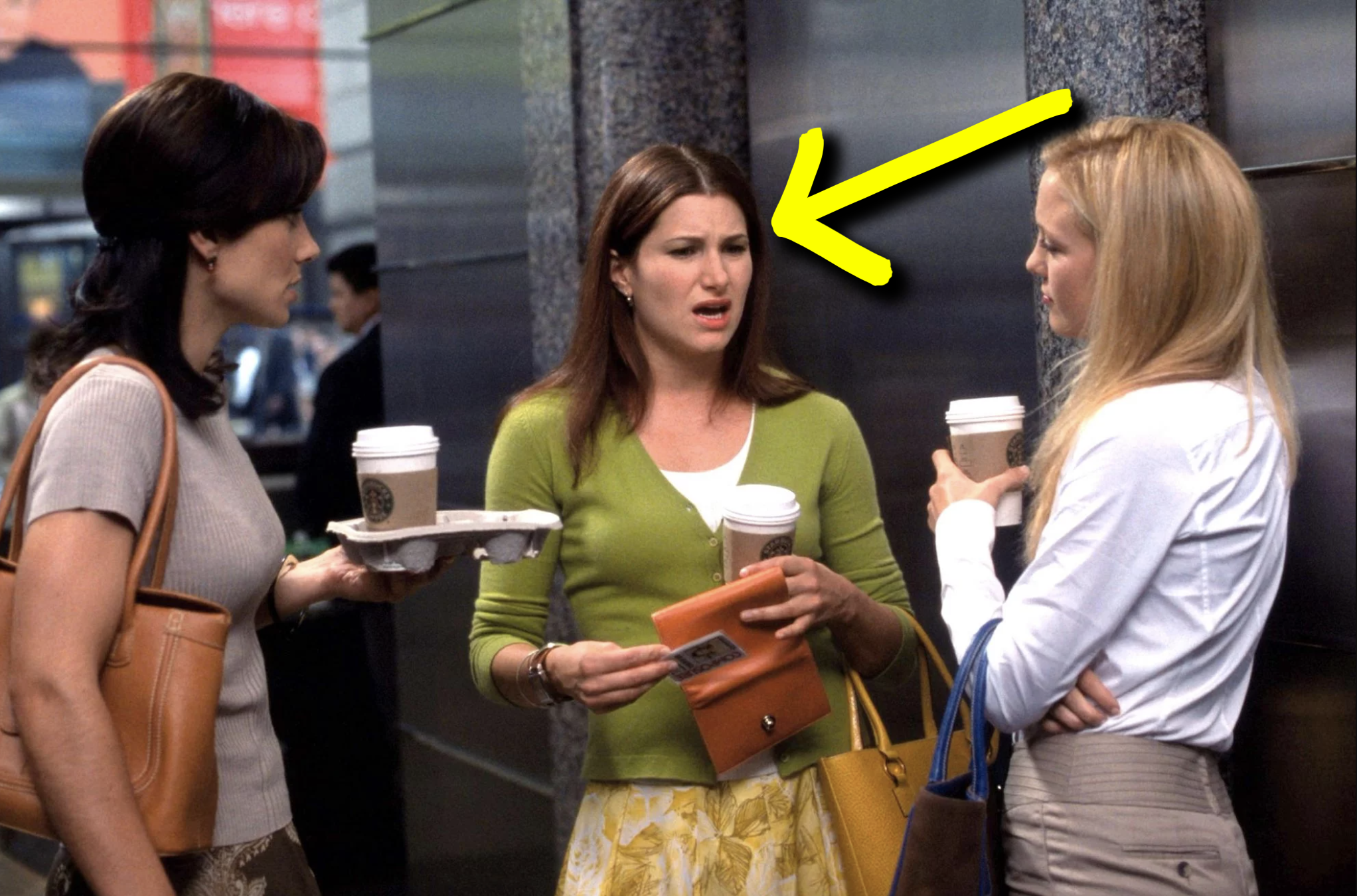 Kathryn in the movie holding a cup of coffee and gossiping 