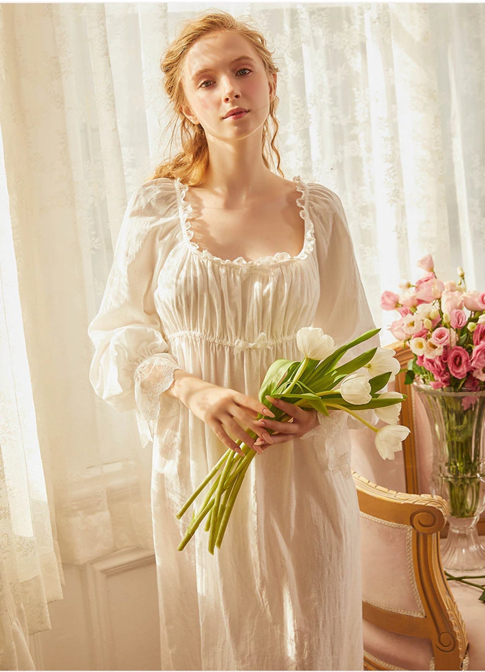 a model wearing the white victorian cotton square nightgown and holding a bouquet of tulips