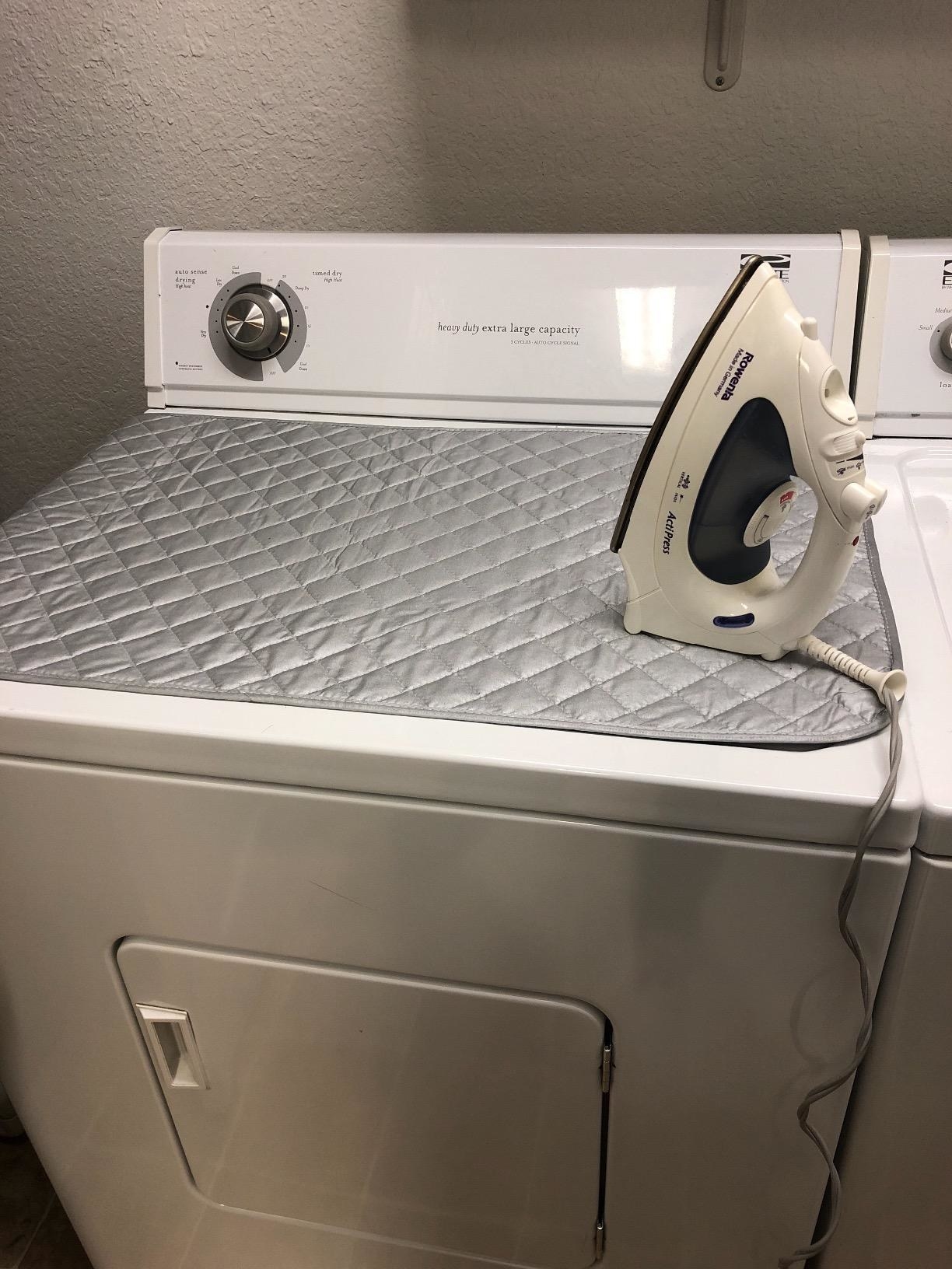 a reviewer photo of the magnetic ironing mat on a dryer