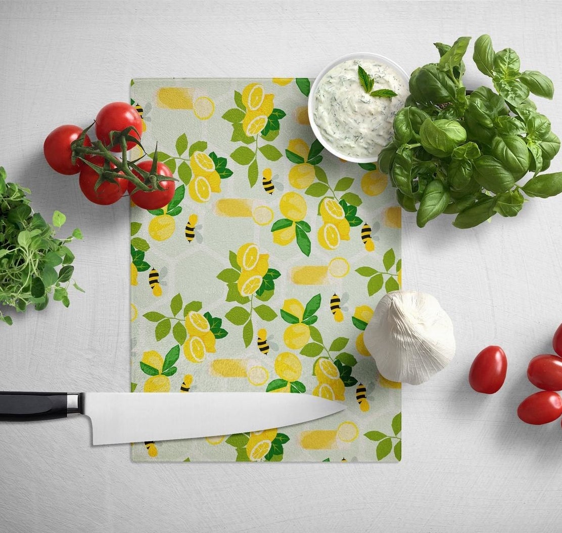 rectangle cutting board with illustrations of lemons and bees all over it