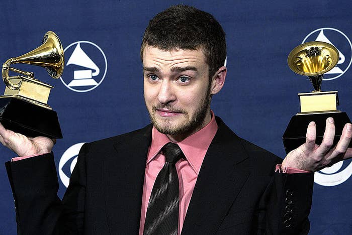Justin Timberlake holding up his two Grammy awards 