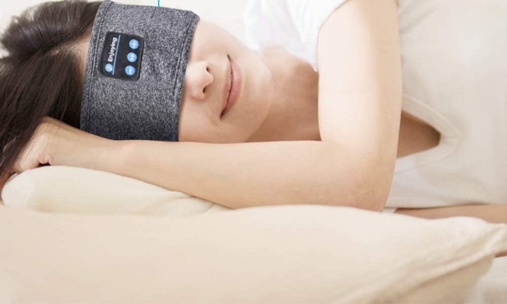 A person lying on their side while wearing the headband over their eyes