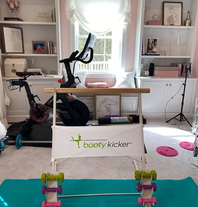 Booty Kicker bar with weights on the bottom in a reviewer's home gym