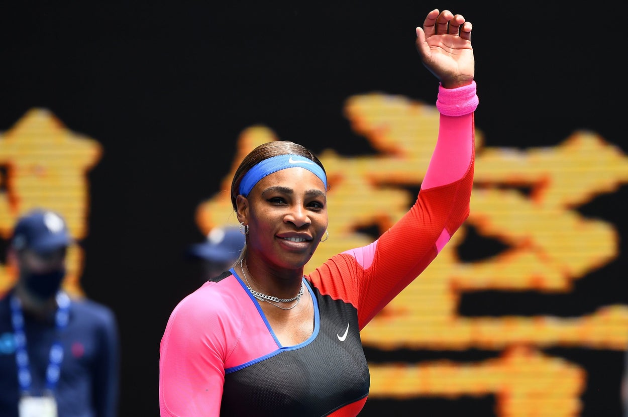 Serena Williams raises her arm in the air. 