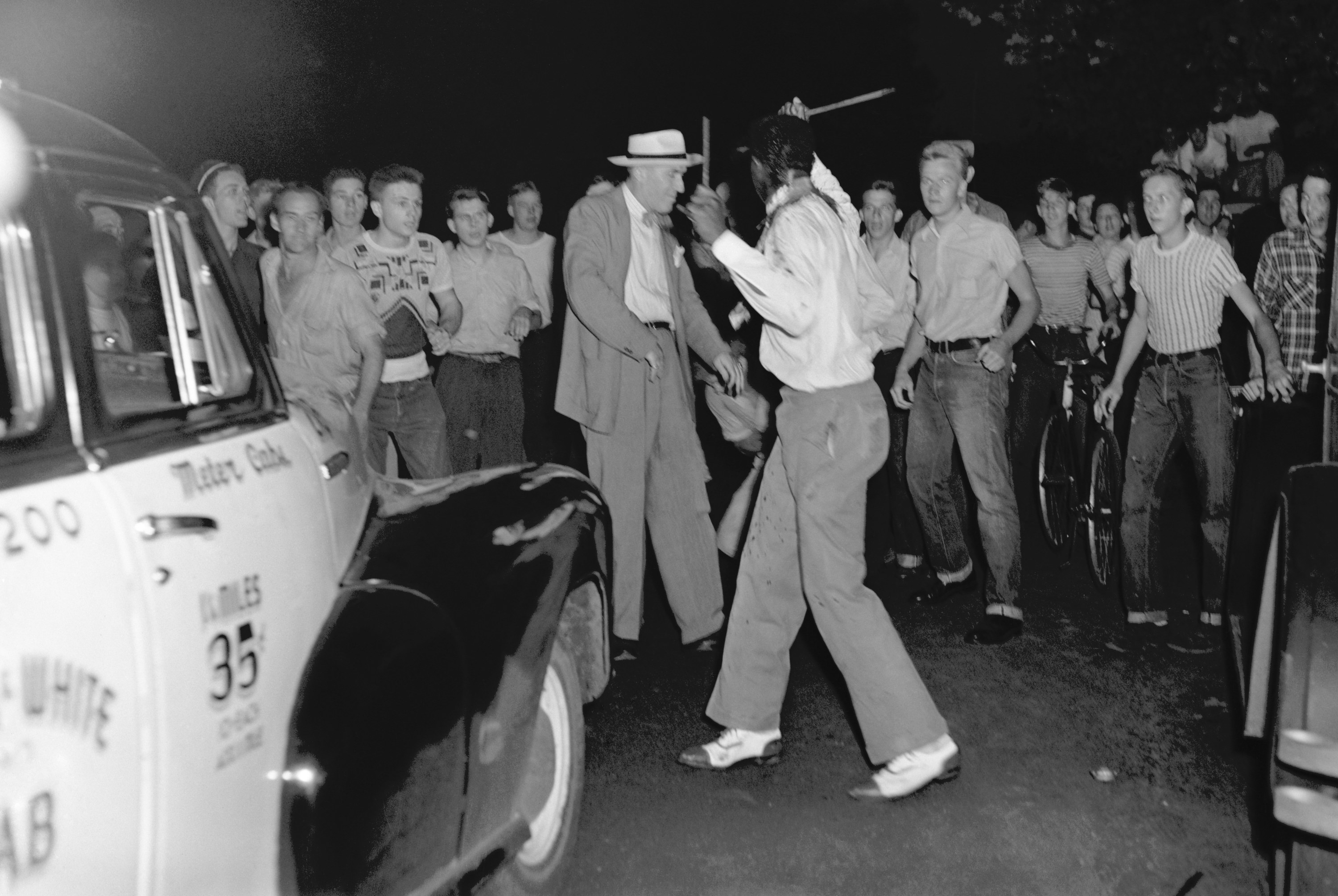 Surrounded by an angry, jeering mob, a bloodstained Black man tries to fight off his attackers during a race riot in St. Louis