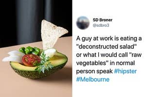 Half an avocado with a cherry tomato, piece of cucumber, onions and a corn chip resting where the seed normally sits, next to a tweet that reads "A guy at work is eating a 'deconstructed salad' or what I would call 'raw vegetables' in normal person speak"