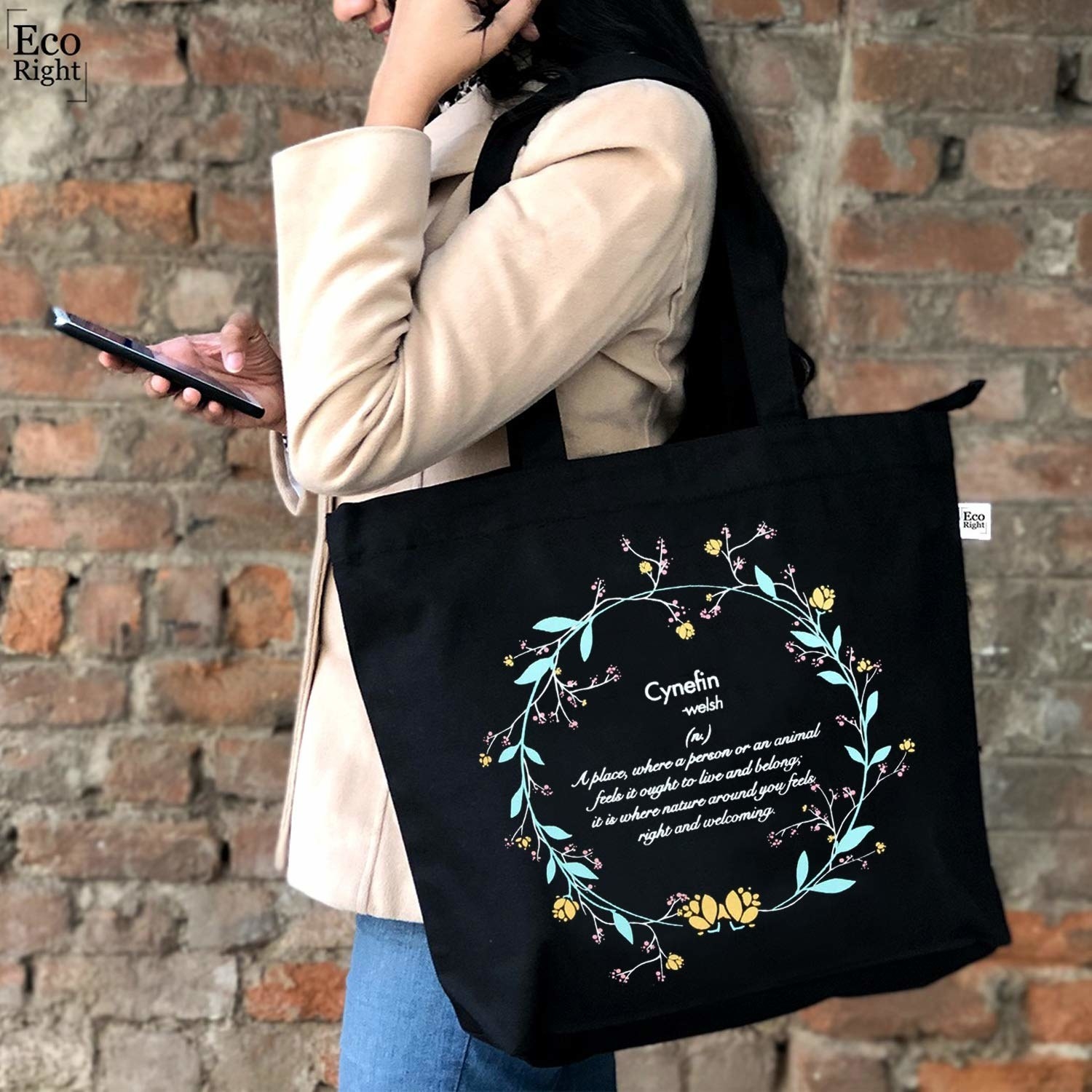 A black tote bag with a floral design and the definition of &#x27;cynefin&#x27; written on it.