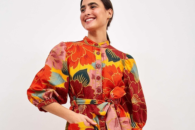model wearing a super colorful floral dress with button up detailing and a tie waist