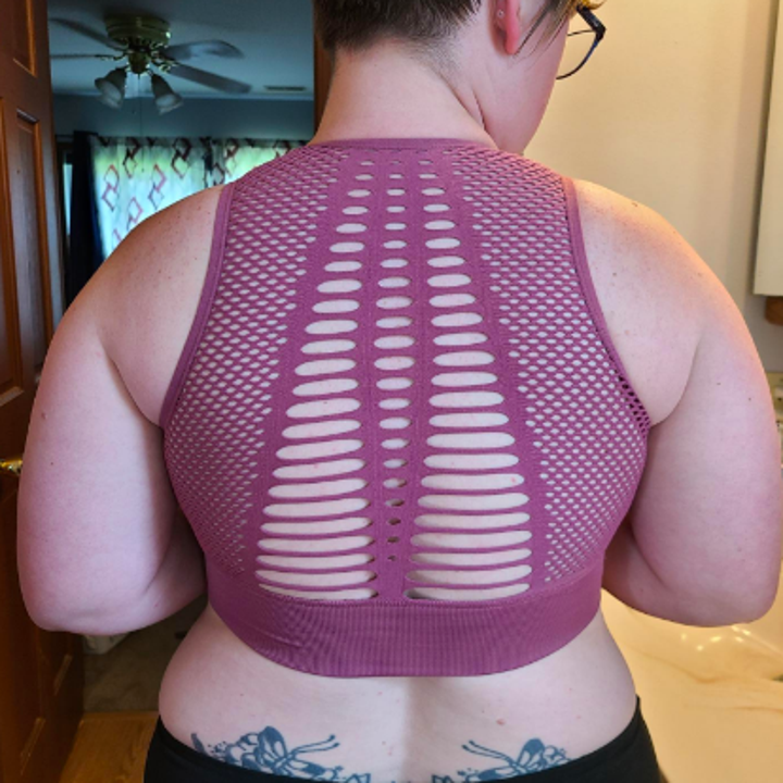 Reviewer showing the mesh and cut design on the back of the bra 