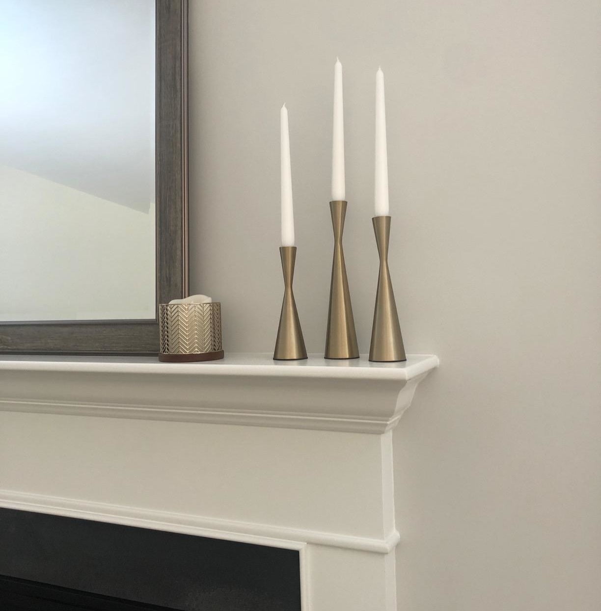 reviewer image of the three candlestick holders in gold that are different sizes and tapered in the middle