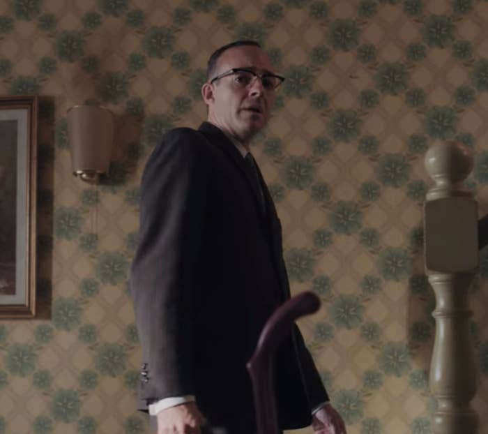 A man is holding a suitcase as he is making his way up the stairs 