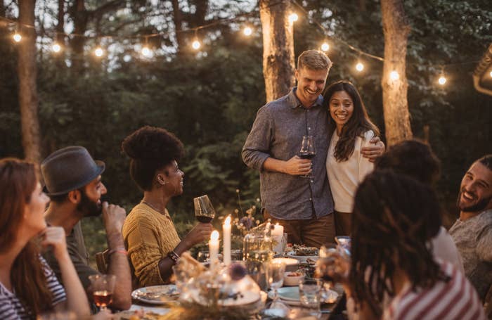 A couple with their group of friends casually dressed for a dinner party