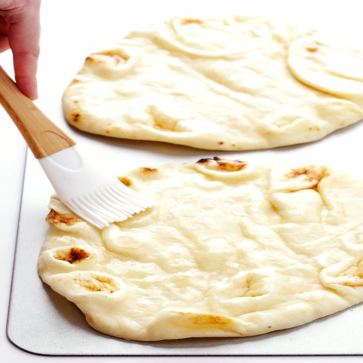 Brushing flatbread with olive oil.
