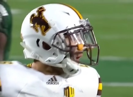 White helmet with a brown cowboy outlined in yellow