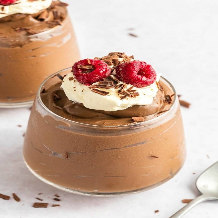 Avocado chocolate mousse with whipped cream and raspberries.