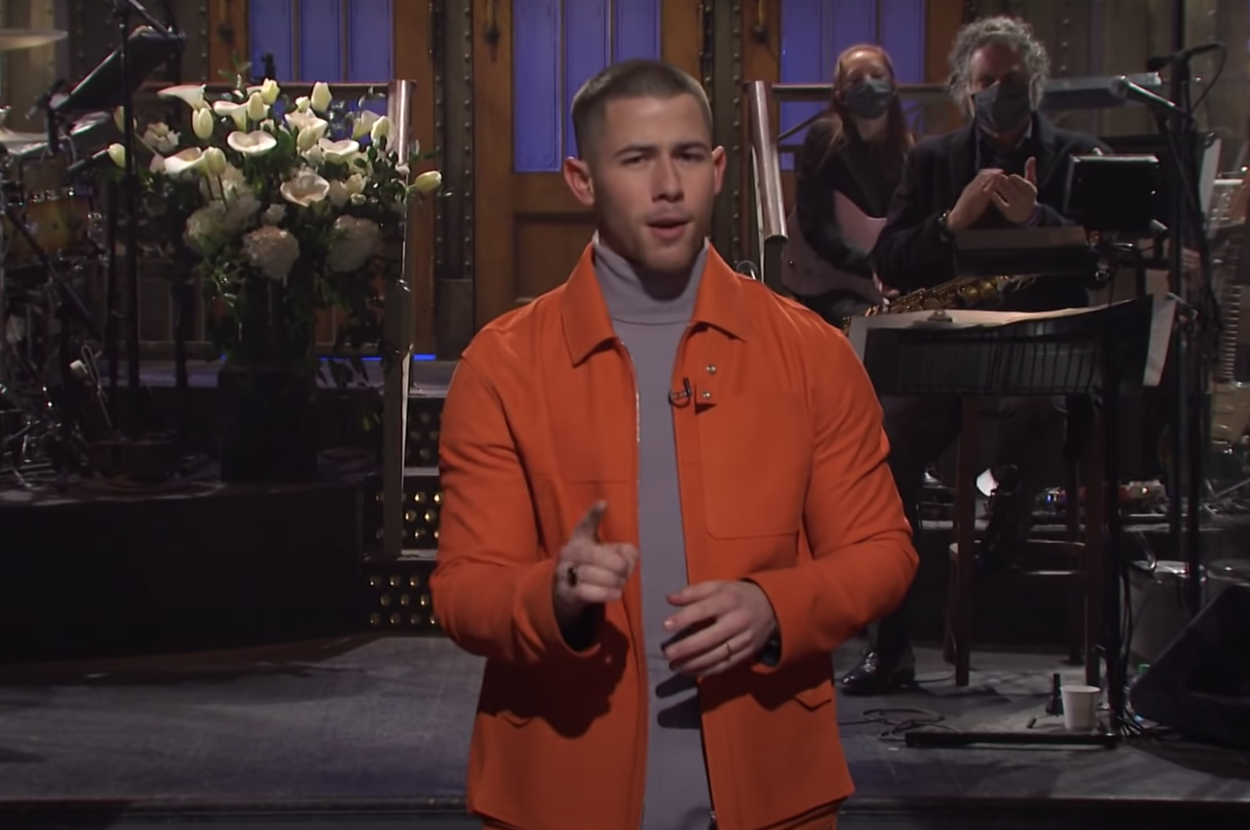 Nick Jonas standing in front of a band on "SNL"