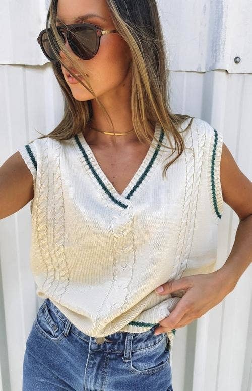 model in slouchy cream cable knit sweater vest with green trim