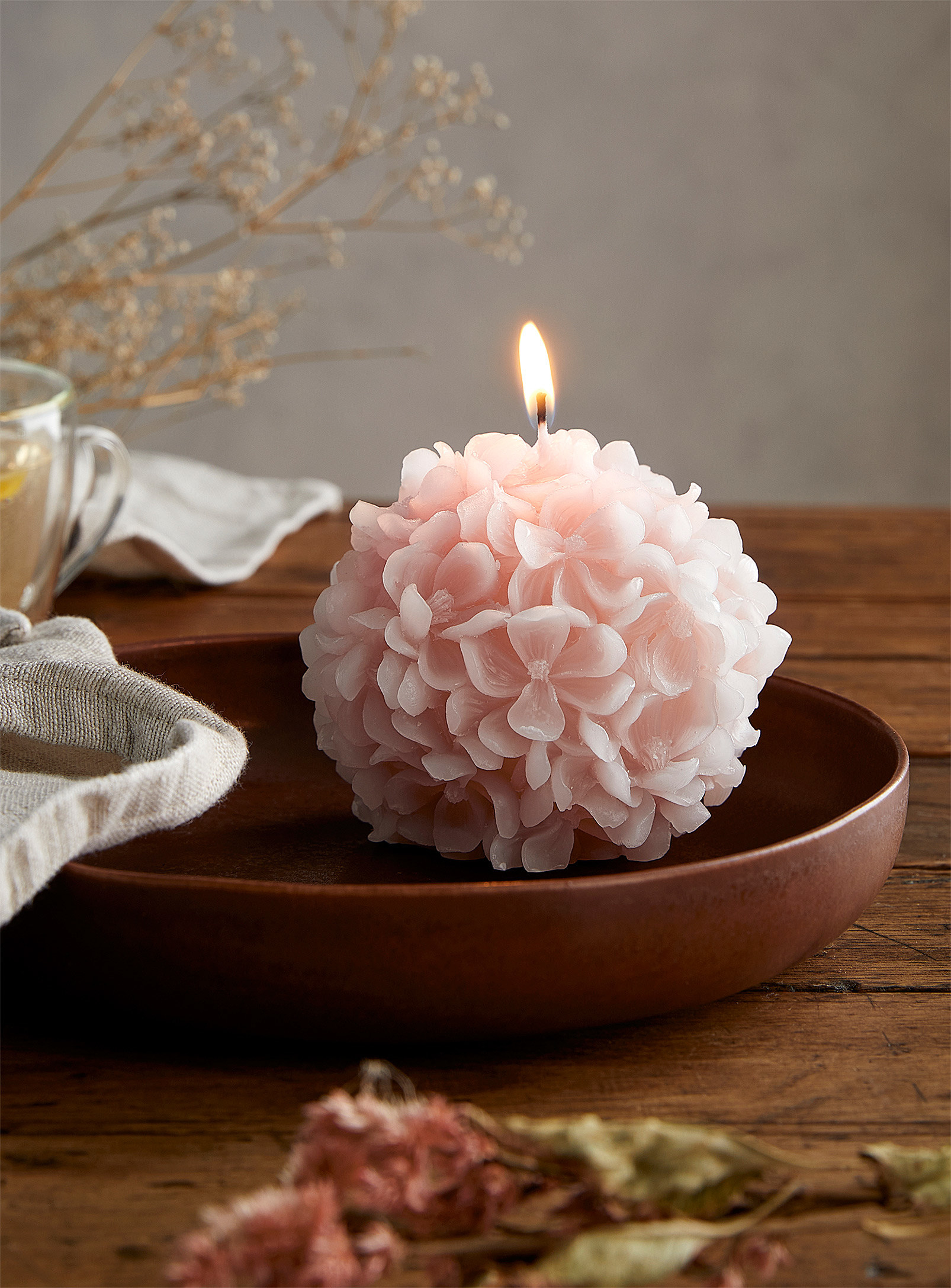 A small round candle that looks like a full hydrangea candle
