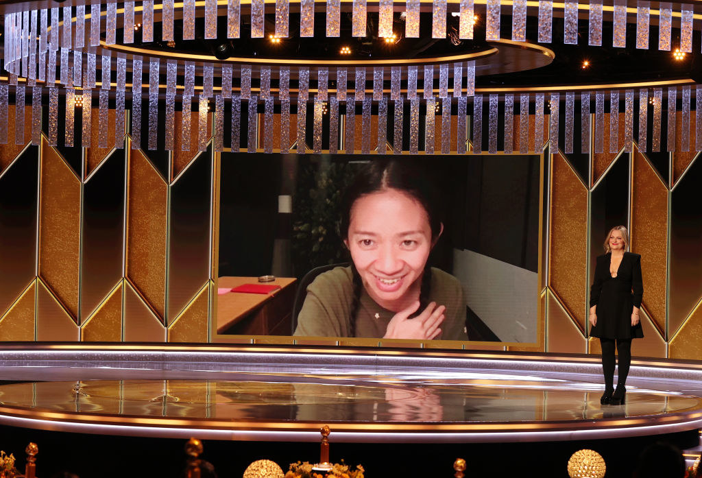 Amy Poehler stands on a stage presenting the award to Zhao