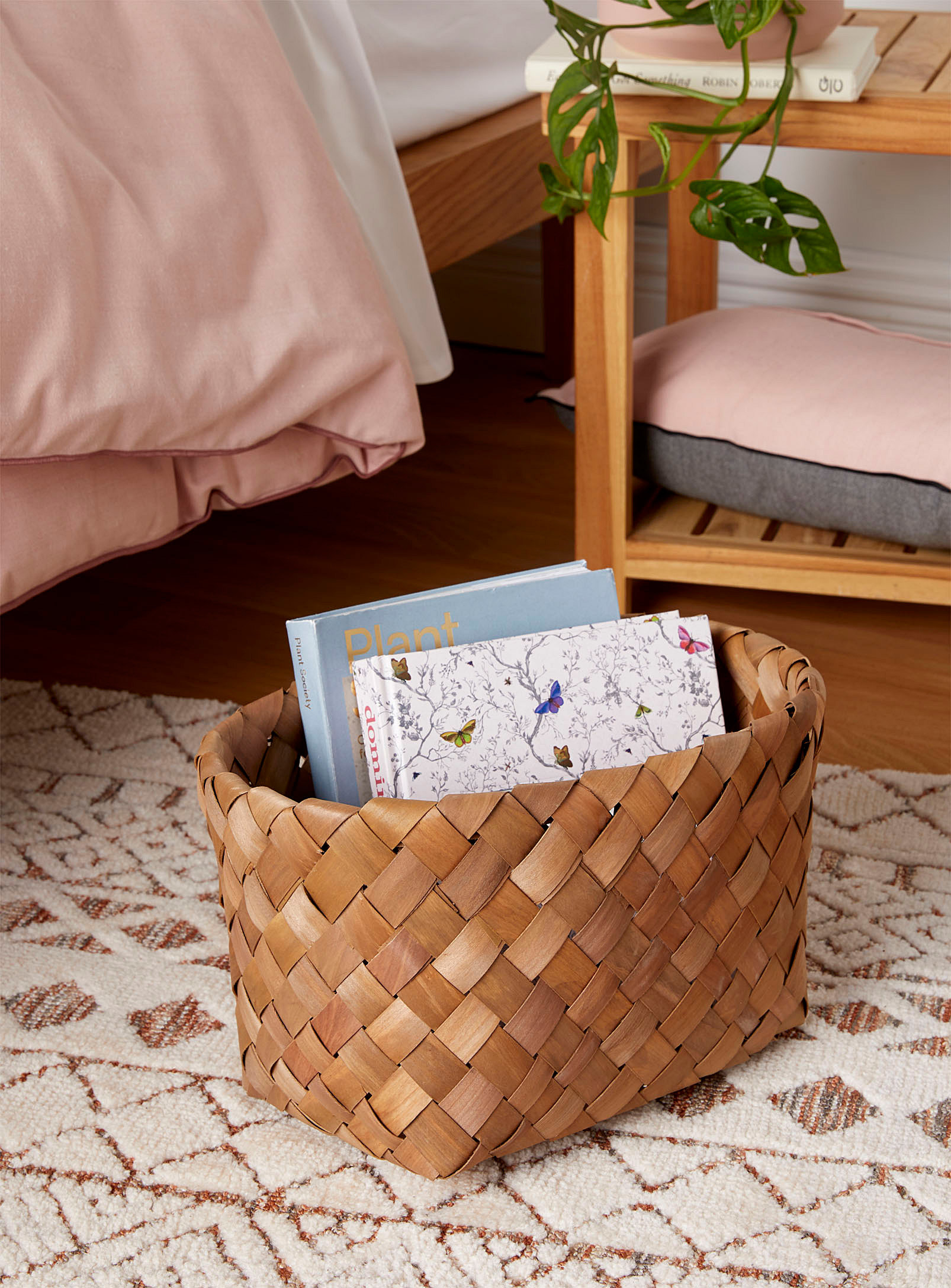 A woven basket on a rug filled with books
