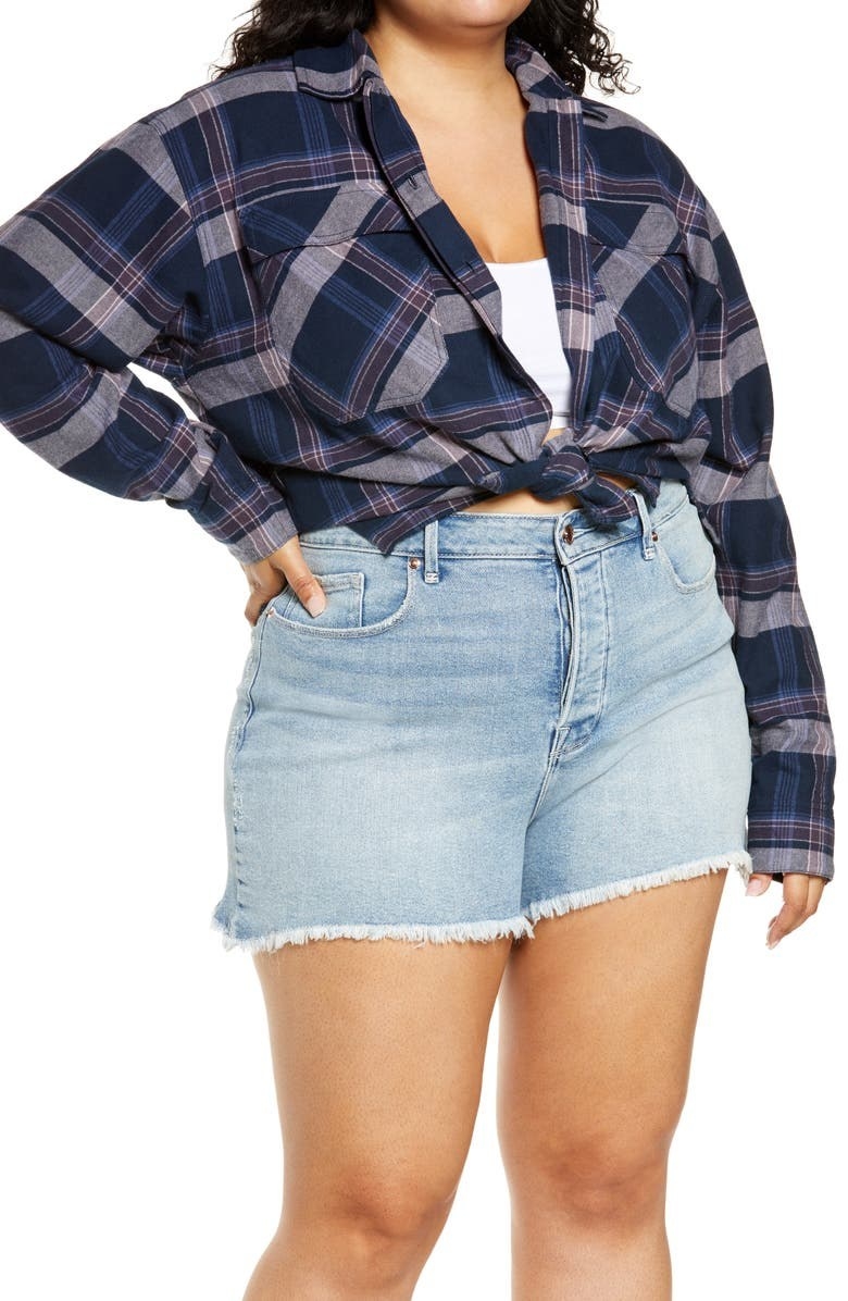 model wearing an oversized plaid top tied in a knot in the front