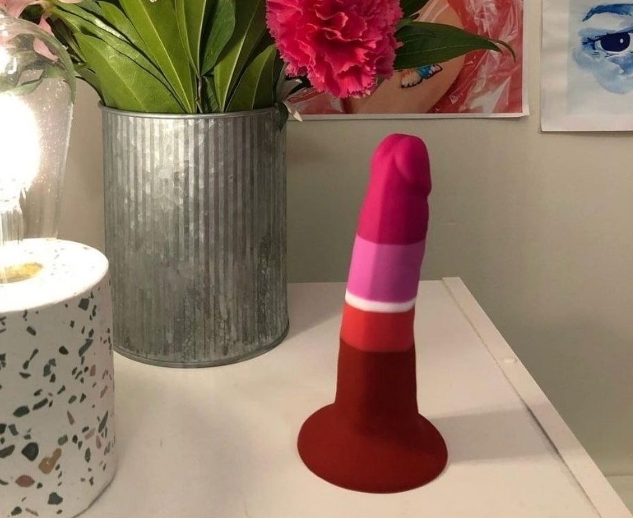 The dildo, which is red and pink, and has a large suction base