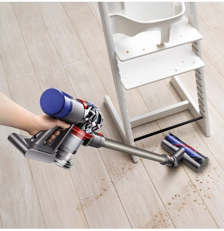 blue and silver dyson stick vacuum cleaning hard wood floor