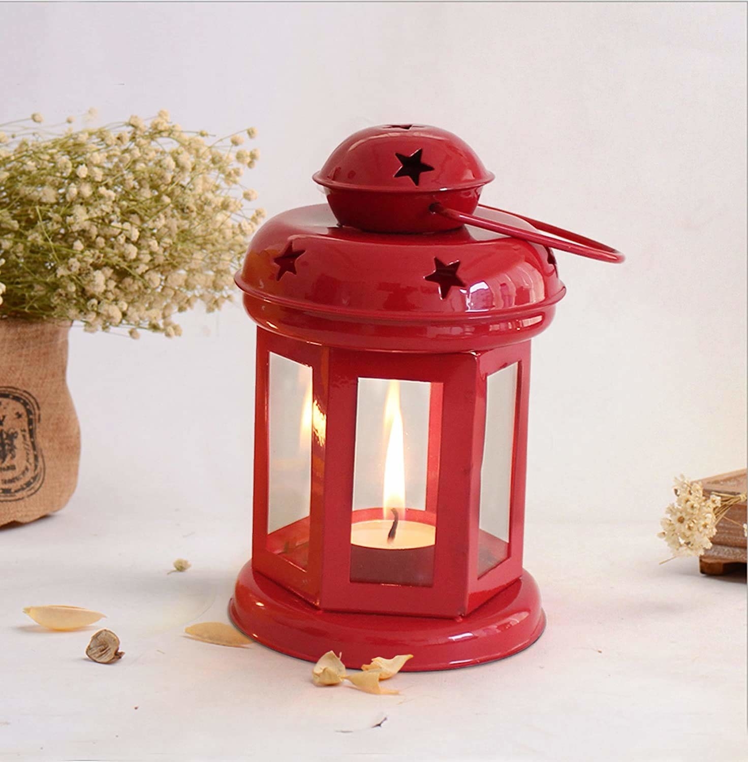 A red tealight holder with a tealight in it 