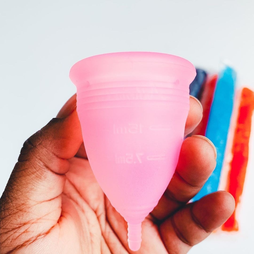 A person&#x27;s hand holding a menstrual cup