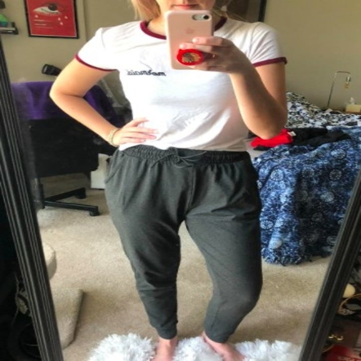 person wearing gray slouchy joggers in front of a mirror