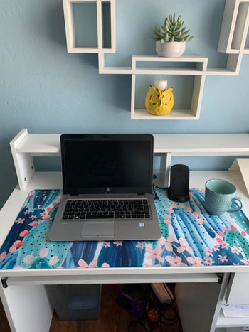 reviewer image of the rectangle mat with cactus blue and green print on it on a work space