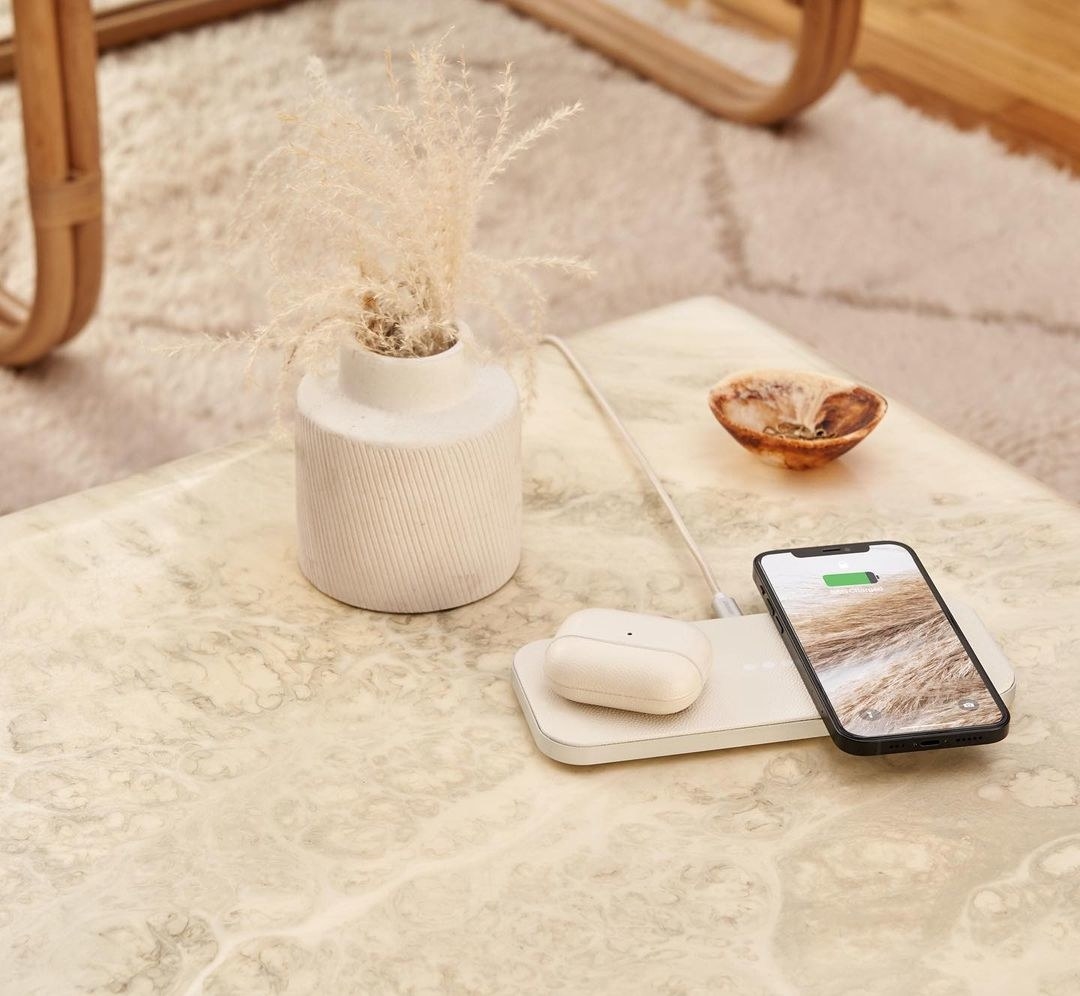long rectangular-shaped wireless charger in white with AirPods and an iPhone sitting on it
