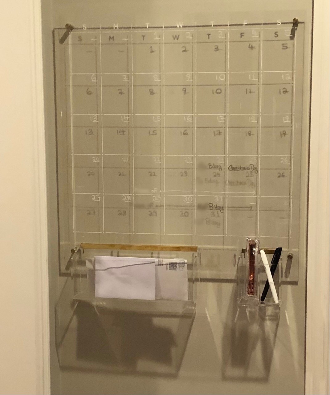 reviewer image of the square clear calendar hanging on the wall, showing a schedule for the month