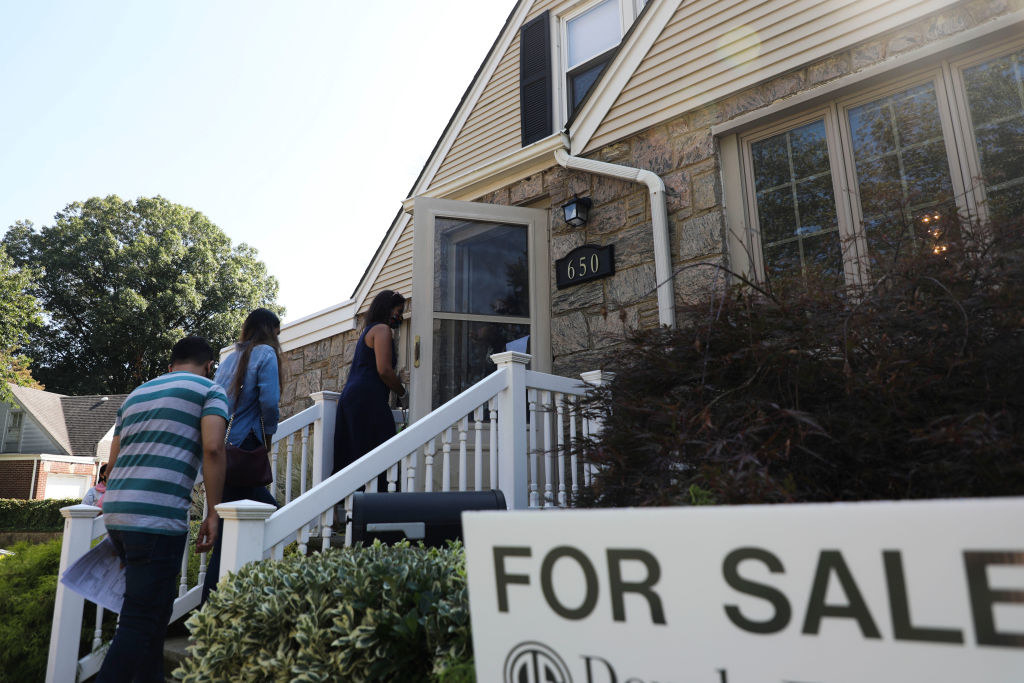 Masked people entering house with a &quot;for sale&quot; sign