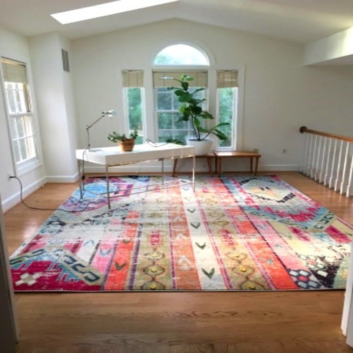 sparse office with a large colorful rug placed in it