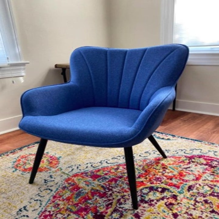 blue accent chair sitting in the middle of a room