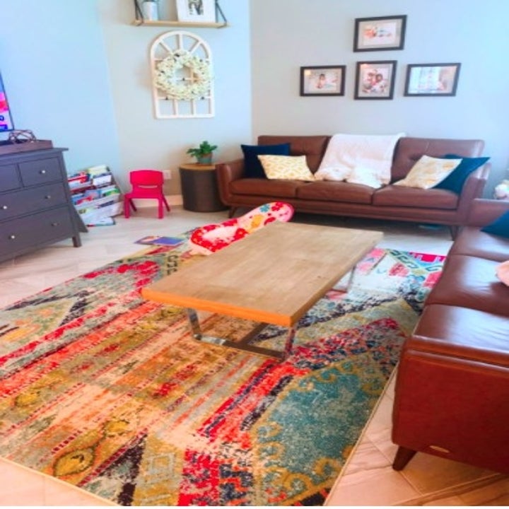 a living room with a bright colorful rug underneath the coffee table