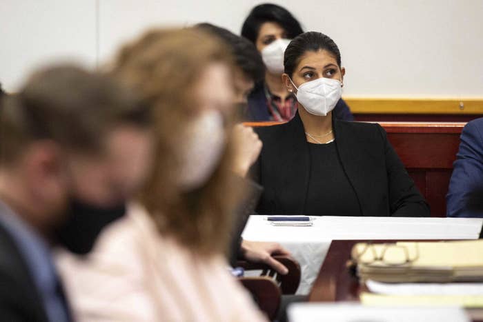 A woman wearing a face mask sits in court