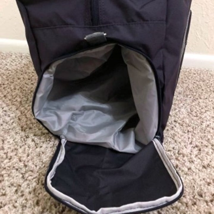 side view of a gym bag with the pouch for shoes open