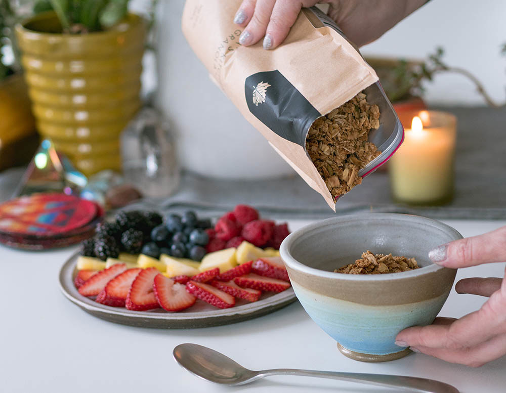 a model pouring granola out of a bag into a bowl