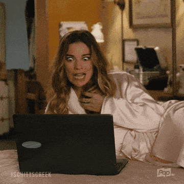 gif of alexis from schitts creek on a laptop and saying yum