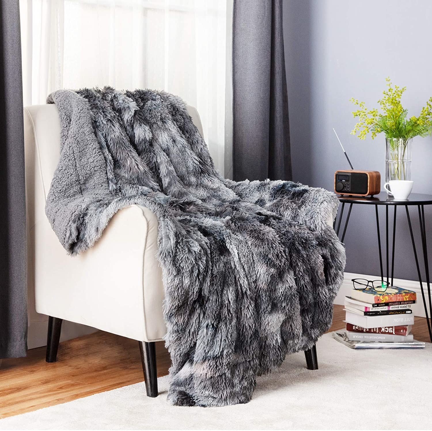 gray faux fur blanket draped over a white accent chair