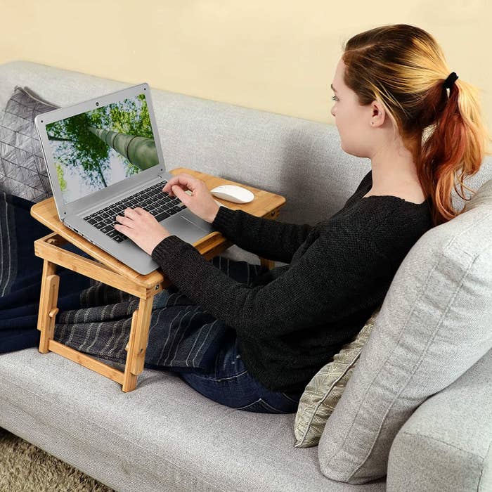 person using a bamboo desk to work on their computer