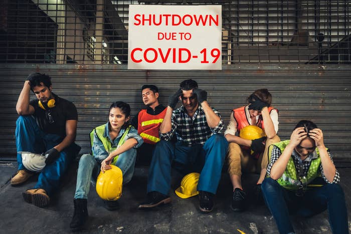 Construction workers sitting down on a site, unemployed because of COVID-19