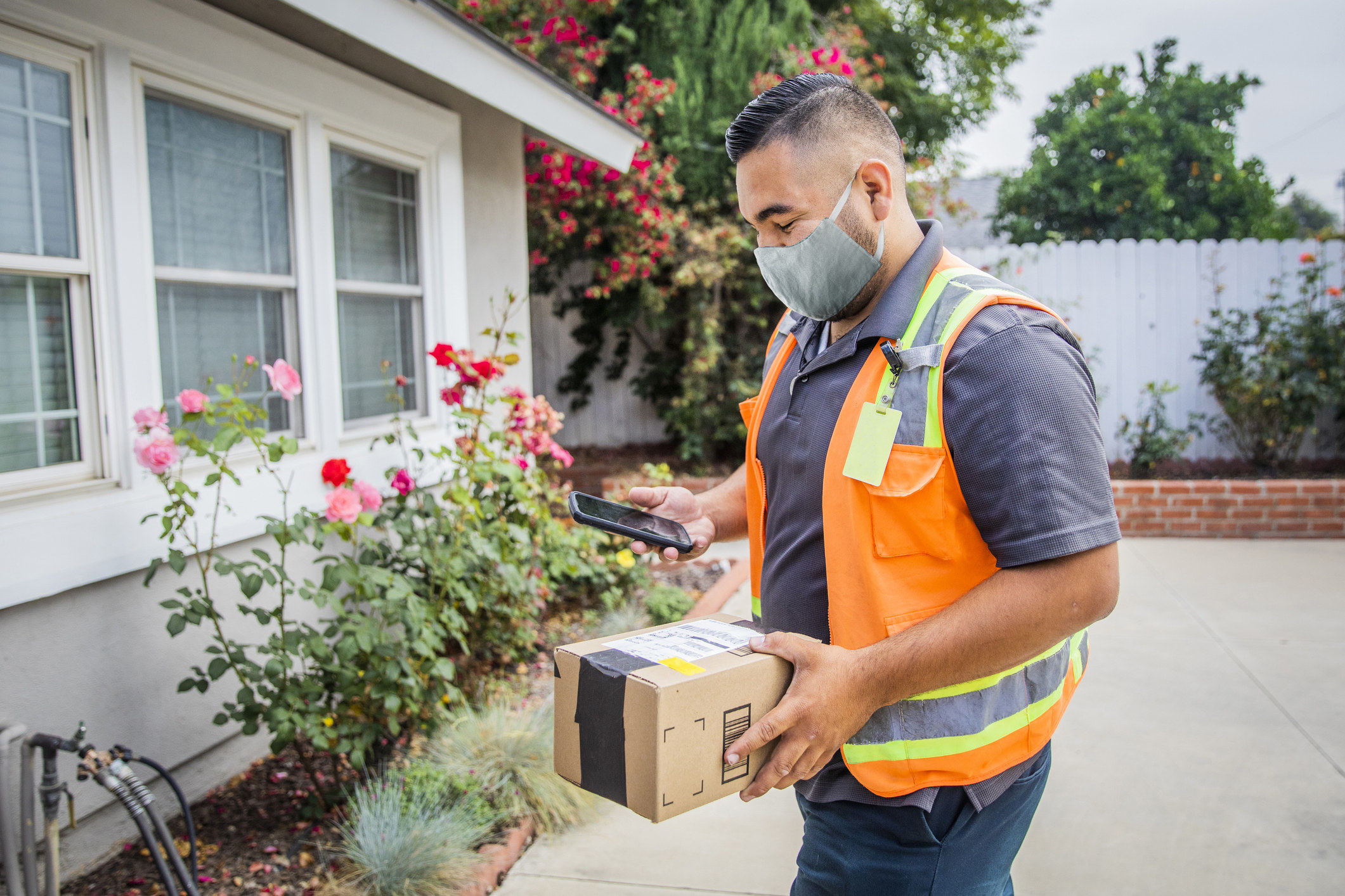 Delivery man dropping a package off at someone&#x27;s house