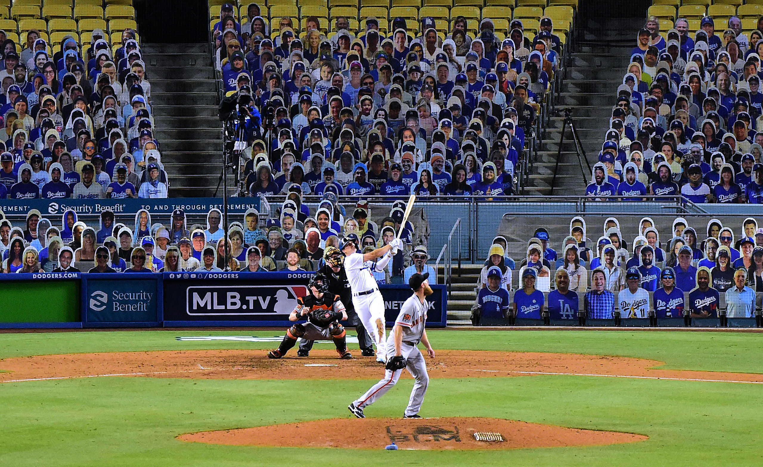 Hernandez hits the baseball while behind him the stadium is filled with cutouts of people in the stands